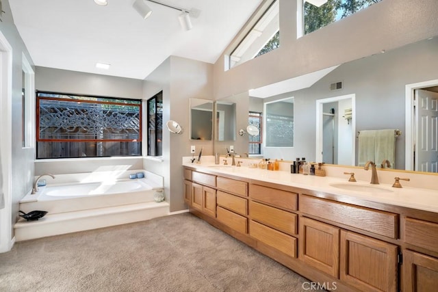 bathroom with carpet, double vanity, visible vents, a sink, and a bath