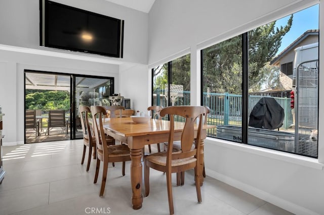 dining space featuring a wealth of natural light, light tile patterned flooring, and baseboards