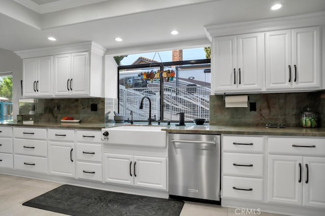 kitchen featuring dark countertops, white cabinetry, and dishwasher