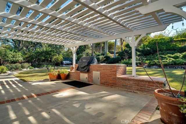 view of patio with exterior kitchen, a grill, and a pergola