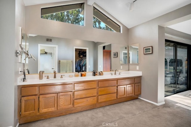 full bathroom with high vaulted ceiling, visible vents, a sink, and double vanity