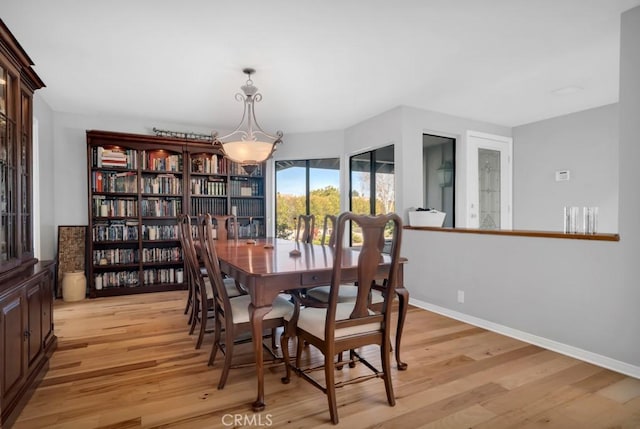 dining area with baseboards and light wood-style floors