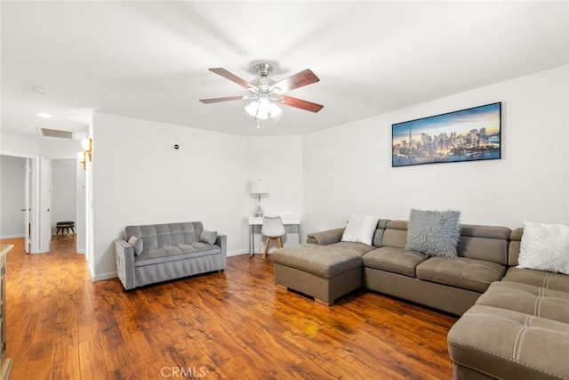 living area with a ceiling fan, wood finished floors, visible vents, and baseboards