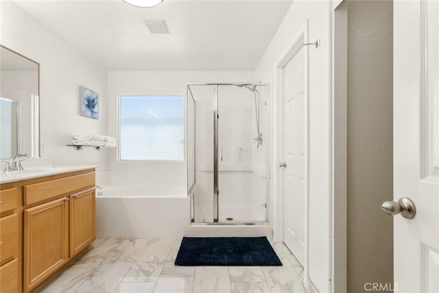 full bathroom featuring a garden tub, marble finish floor, a shower stall, and vanity