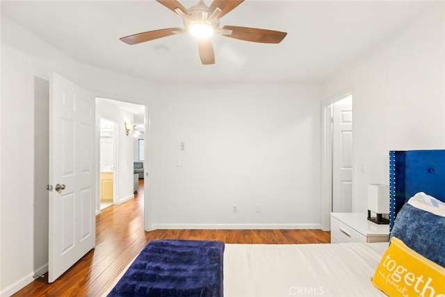 bedroom featuring ceiling fan, baseboards, and wood finished floors