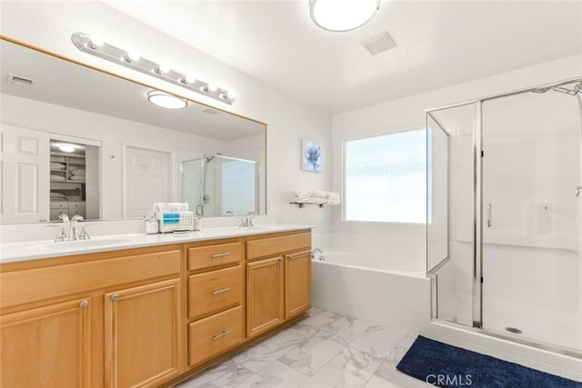 bathroom featuring a garden tub, marble finish floor, a stall shower, and a sink