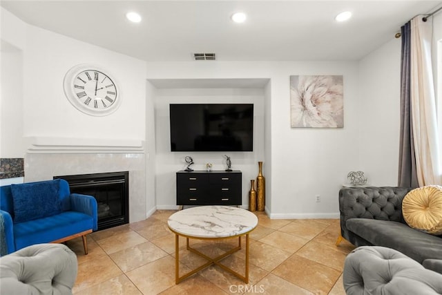 living area featuring a high end fireplace, visible vents, baseboards, and recessed lighting