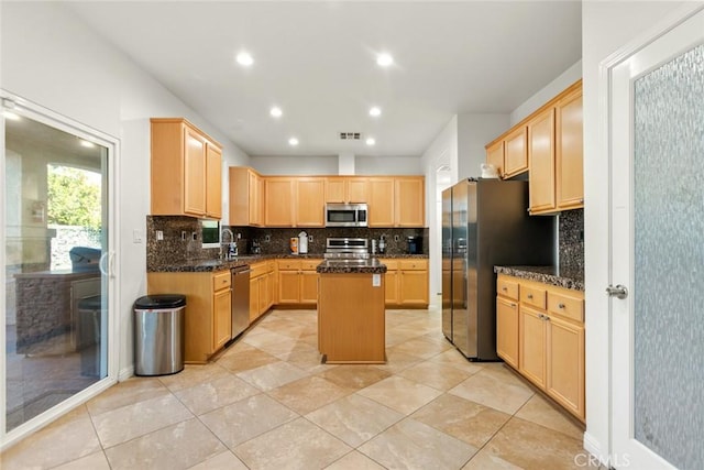 kitchen featuring a sink, stainless steel appliances, a kitchen island, and light brown cabinets