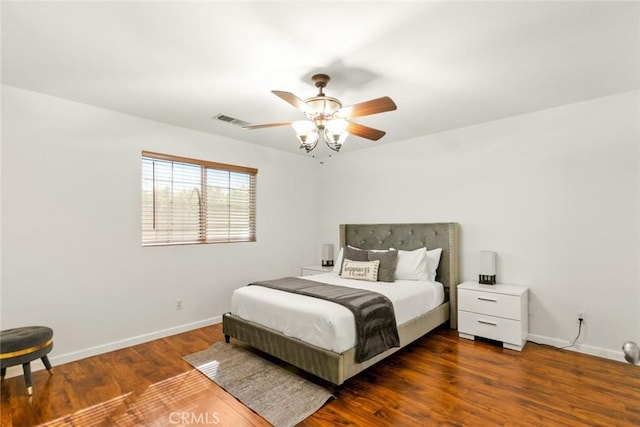 bedroom with a ceiling fan, baseboards, visible vents, and wood finished floors