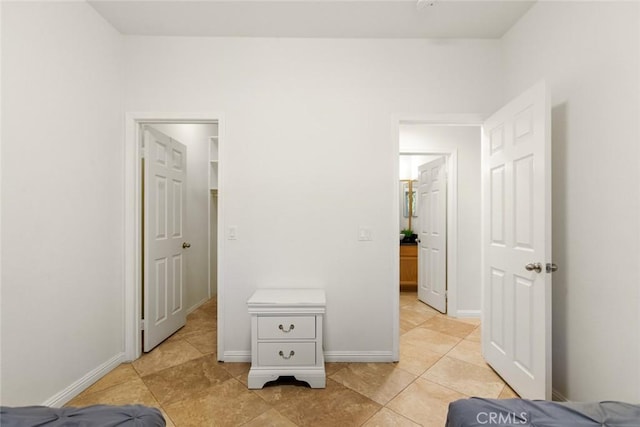 bedroom featuring light tile patterned floors and baseboards