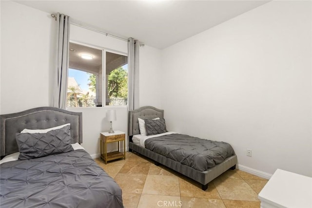 bedroom with light tile patterned flooring and baseboards