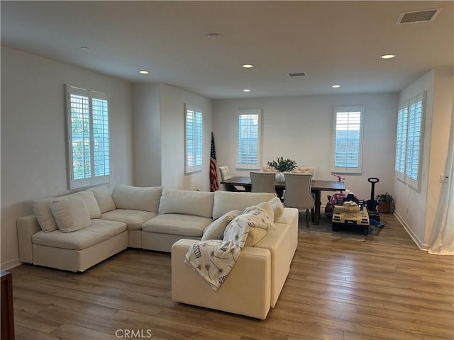 living room featuring baseboards, wood finished floors, visible vents, and recessed lighting