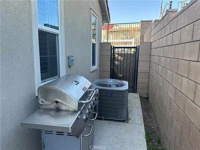 view of patio with fence, grilling area, and cooling unit