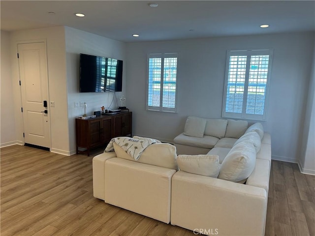 living area with recessed lighting, wood finished floors, and baseboards