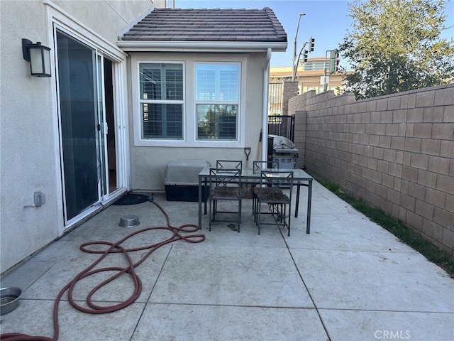 view of patio with outdoor dining space and fence