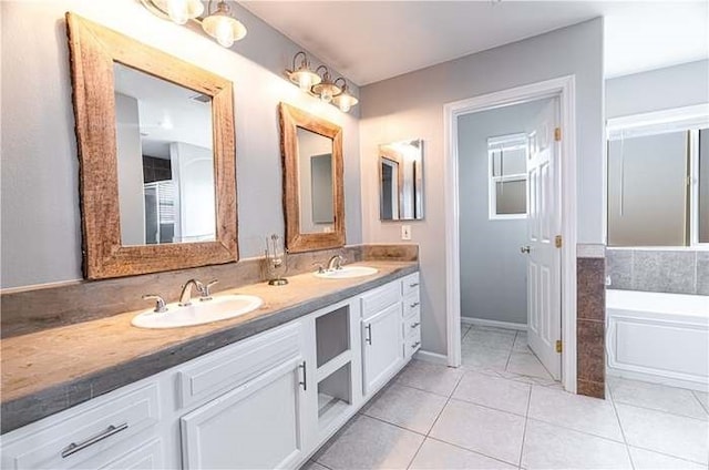 bathroom featuring double vanity, a bath, a sink, and tile patterned floors