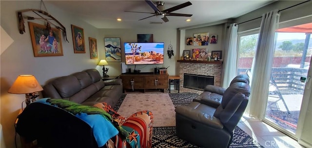 living area featuring recessed lighting, light tile patterned flooring, ceiling fan, and a stone fireplace