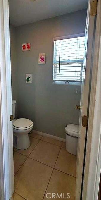 bathroom featuring toilet, tile patterned flooring, and baseboards