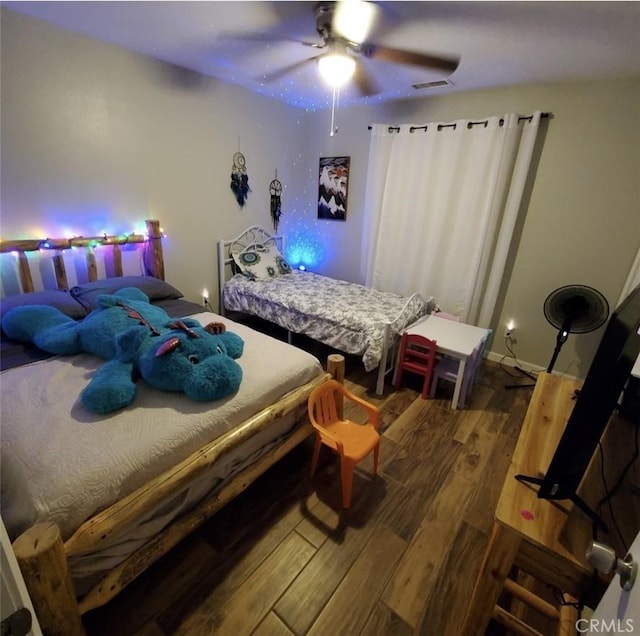 bedroom with visible vents, wood finished floors, a ceiling fan, and baseboards