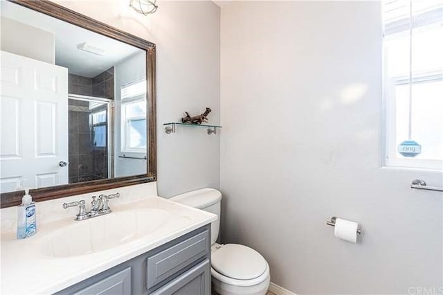 full bathroom with baseboards, a shower stall, toilet, and vanity