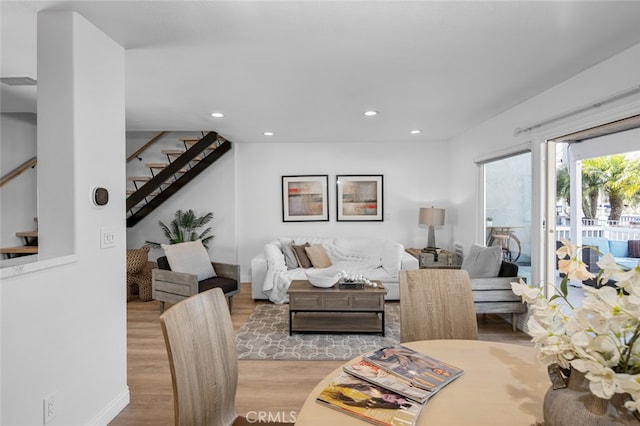 living room with light wood-style flooring, recessed lighting, stairway, and baseboards