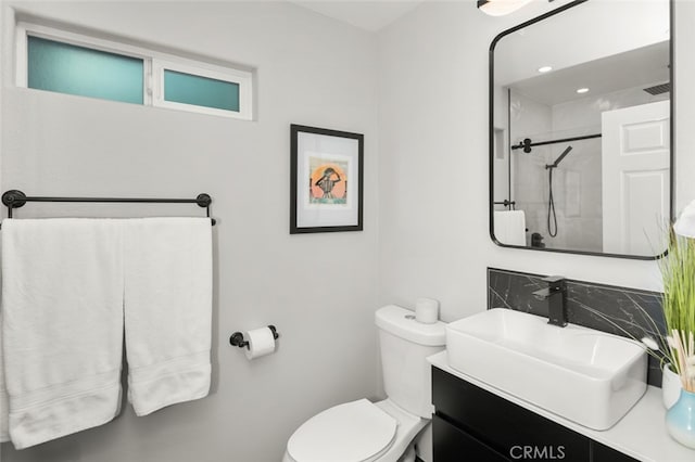 full bath with visible vents, tiled shower, vanity, and toilet