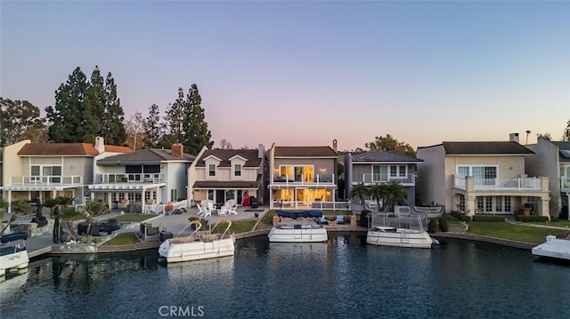 back of house with a water view and a residential view