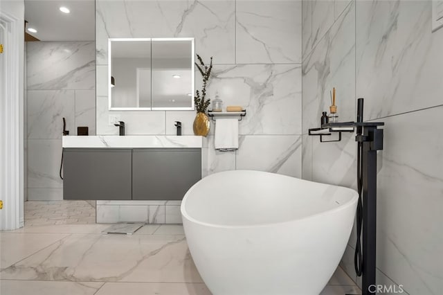 bathroom with stone wall, marble finish floor, and a freestanding bath