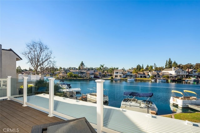 view of dock with a residential view and a water view