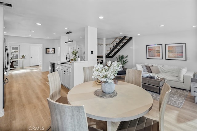 dining area with recessed lighting, visible vents, baseboards, stairs, and light wood finished floors