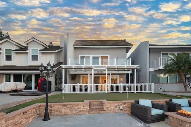 exterior space featuring a balcony, a chimney, a patio, and stucco siding