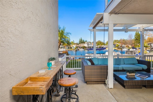 view of patio featuring a water view, outdoor lounge area, and a pergola