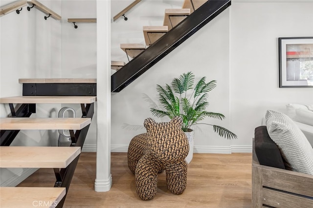 stairs featuring wood finished floors and baseboards