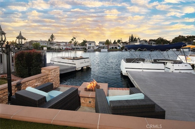 dock area with a water view and a fire pit