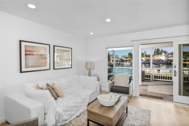 interior space with recessed lighting, a water view, and light wood-style floors