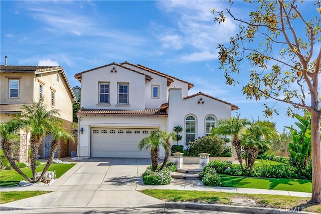 mediterranean / spanish house with stucco siding, driveway, a tile roof, and an attached garage