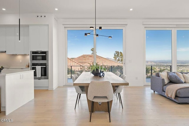 dining space with light wood finished floors, recessed lighting, and a healthy amount of sunlight