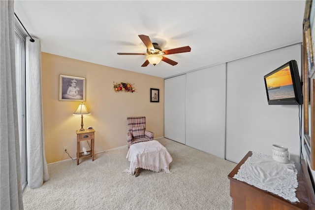 bedroom featuring a ceiling fan, a closet, and light colored carpet