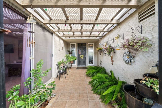 property entrance featuring stucco siding and a pergola