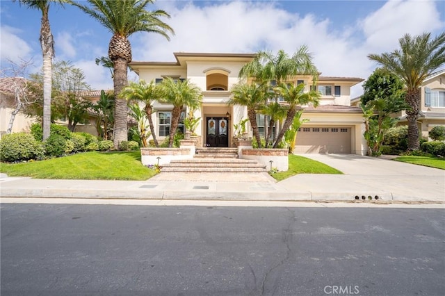 mediterranean / spanish-style home featuring french doors, driveway, an attached garage, and stucco siding