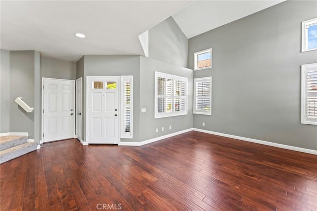 foyer featuring plenty of natural light, dark wood finished floors, stairway, and baseboards