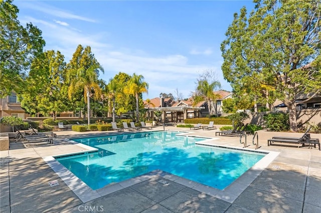 pool with a patio and fence