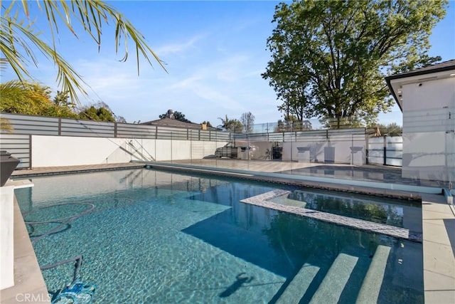 view of pool with a patio, fence, and a pool with connected hot tub