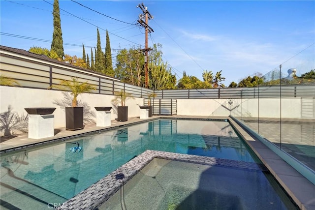 view of swimming pool with a pool with connected hot tub and a fenced backyard