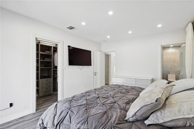 bedroom featuring recessed lighting, a closet, visible vents, a spacious closet, and wood finished floors