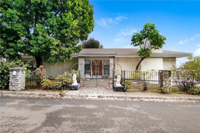 view of front of house with a fenced front yard and stucco siding