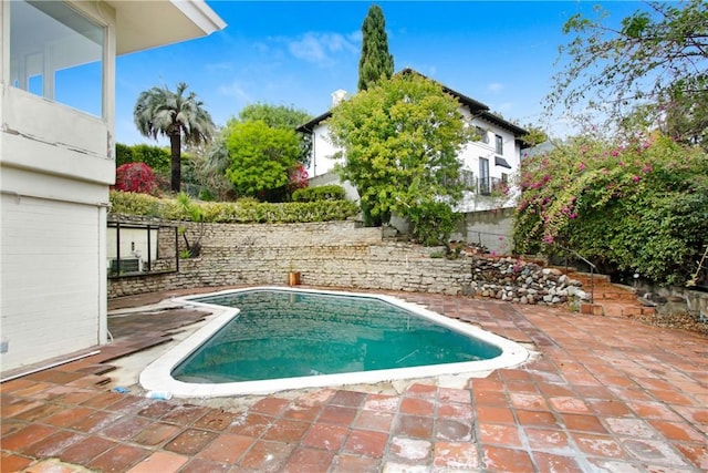 view of swimming pool featuring a patio, fence, and a fenced in pool