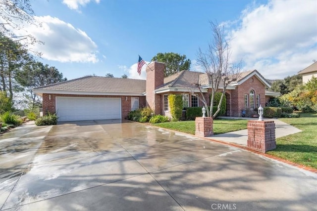 ranch-style home featuring a garage, concrete driveway, brick siding, and a front lawn