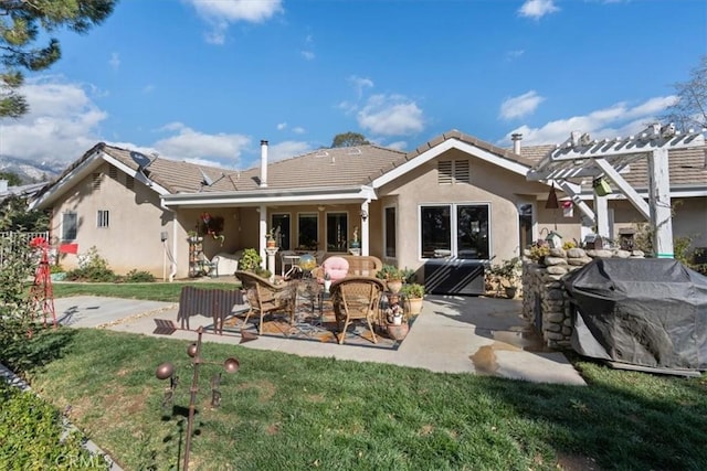 back of house featuring a patio, a tiled roof, and stucco siding