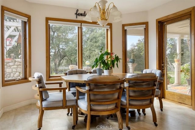 dining area with baseboards and an inviting chandelier